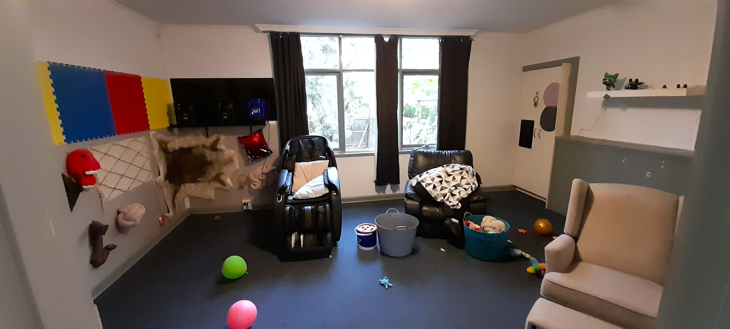 A small sensory room with two arm chairs and sensory items on the wall