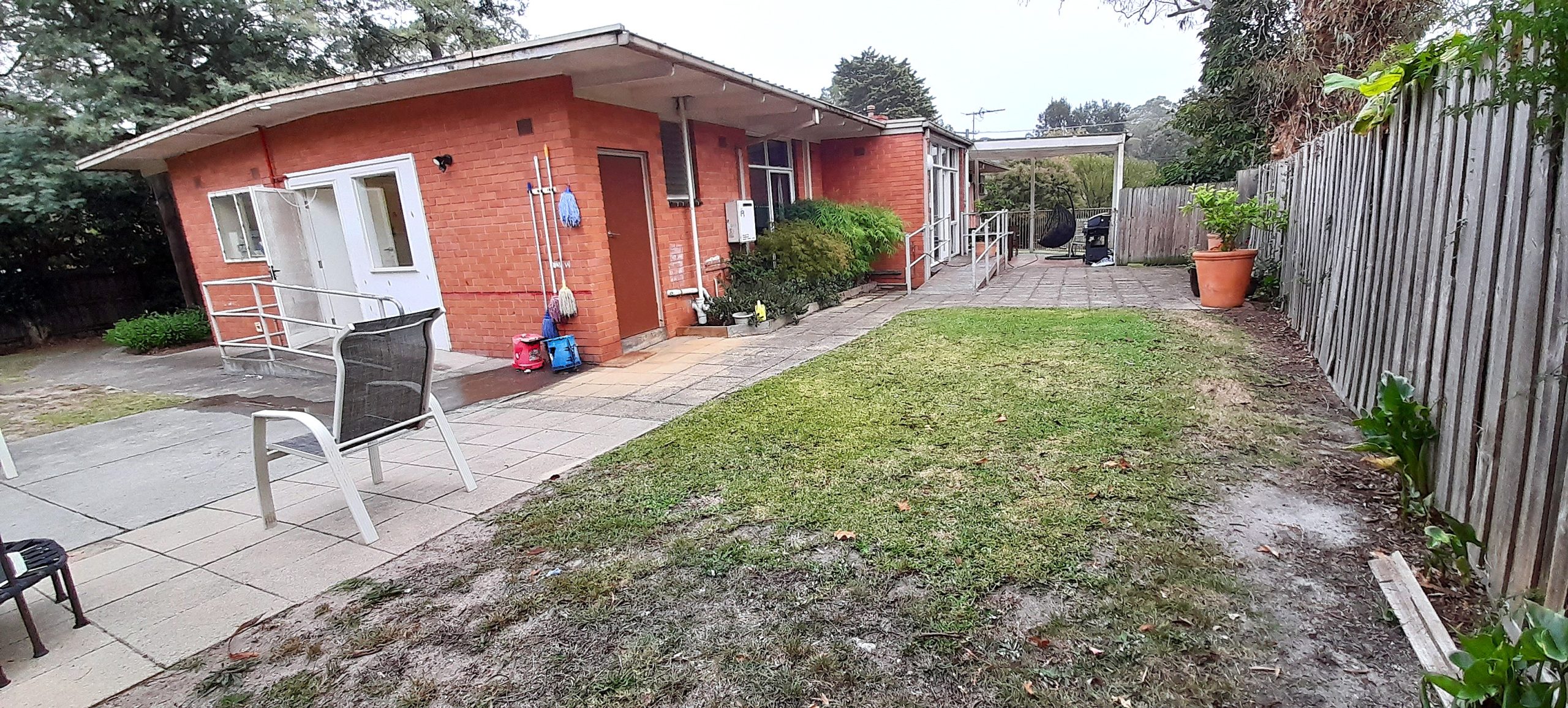 Back of brick home, large grassed backyard